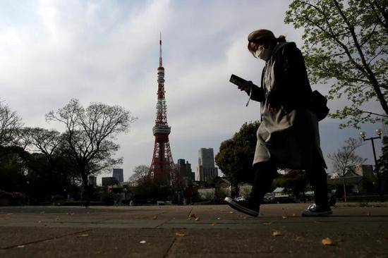 4月3日，一名戴口罩的行人走过日本东京芝公园。新华社/美联