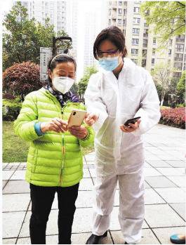 在万科汉阳国际A区，陈念（右）指导社区居民申请湖北健康码