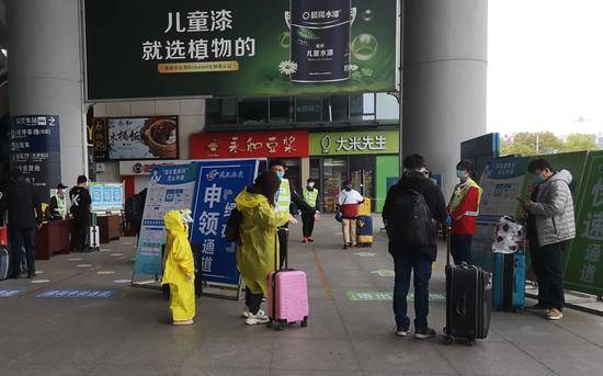 ▲4月5日，武汉站内穿着雨衣的乘客。新京报记者李桂摄