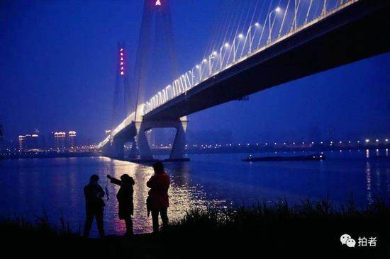 ▲4月2日晚，二七长江大桥下，市民提鱼准备回家。资料图。