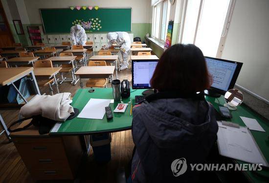 4月7日，在大邱南山小学一间教室，一位女教师准备线上开学。图源：韩联社