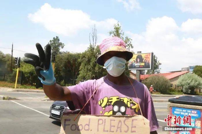 当地时间4日1日，南非约翰内斯堡，一名街头艺人佩戴防护口罩、手套。受疫情影响，南非已经实施全国范围“封城”。中新社记者王曦摄