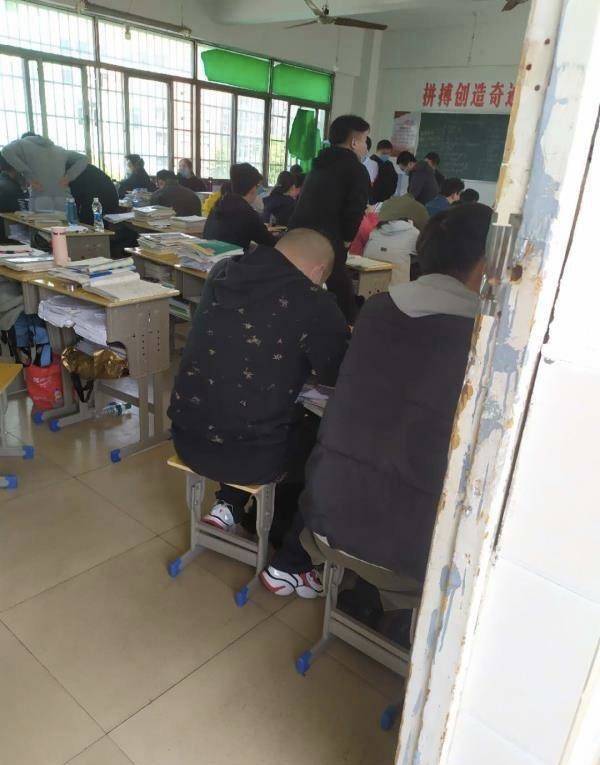 网友提供的照片显示，教室中每两张书桌挨在一起，教室中约有五十余张书桌，学生均佩戴口罩。图源：微博