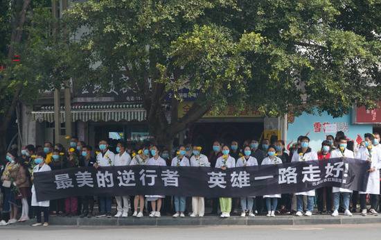 4月4日，在西昌市殡仪馆，当地干部群众自发在路边等待运送牺牲勇士骨灰的灵车。新华社记者王曦摄