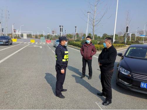 刘勋（中间）在江夏区高速路口巡查武汉出城道路封控情况
