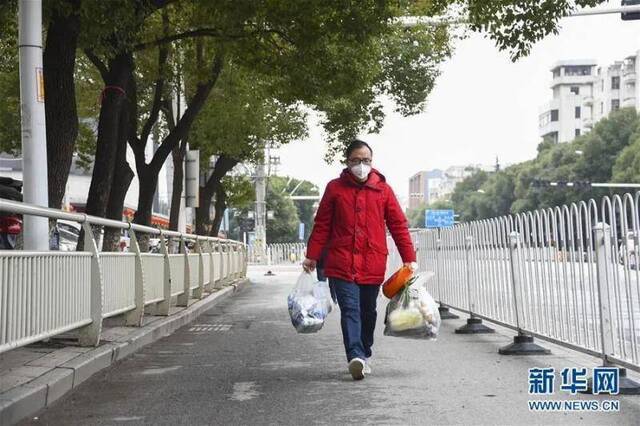 ▲2月8日，在湖北省孝感市，一位外出买菜的居民走在街上。（新华社记者胡虎虎摄）