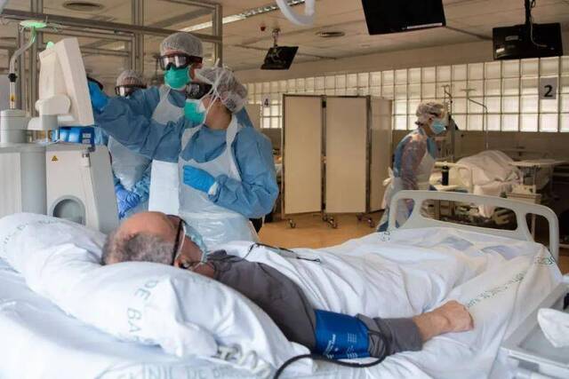 △4月7日，在西班牙巴塞罗那医院，医务人员在病房内照顾新冠肺炎患者。