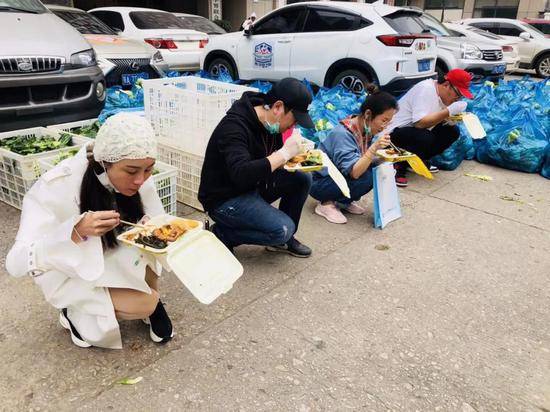 3月21日，队员在转运蔬菜空隙蹲在路边吃午餐。