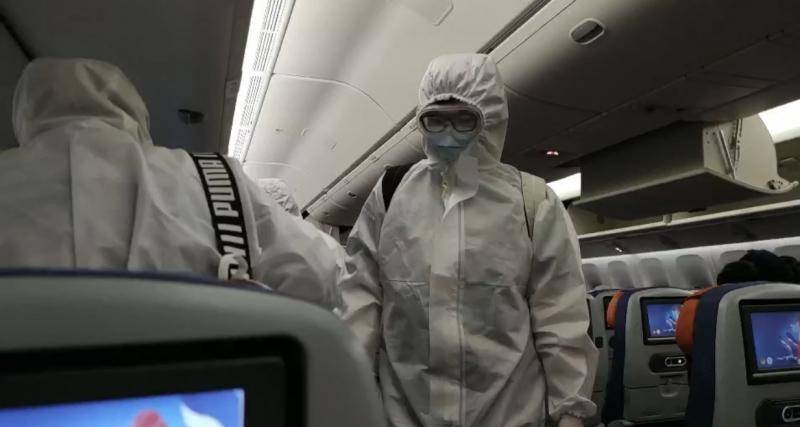 航班上大多数旅客佩戴口罩、护目镜，身穿防护服。受访者供图
