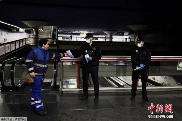 当地时间4月13日，西班牙马德里，警察在地铁站向民众分发免费的防护口罩。