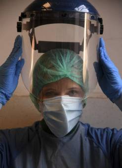  4月12日，在意大利首都罗马，圣斯皮里托医院的医生莫妮卡·卡尔福拉在进入新冠肺炎病区前穿戴防护设备。