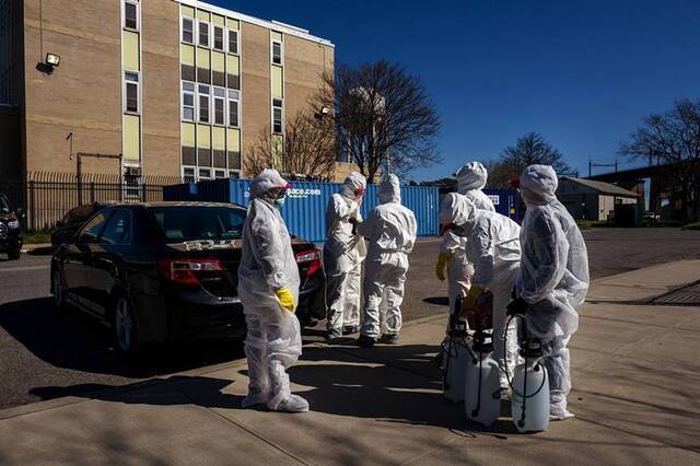 一队清洁工人正准备进入沃兹岛的收容所图源：《纽约时报》