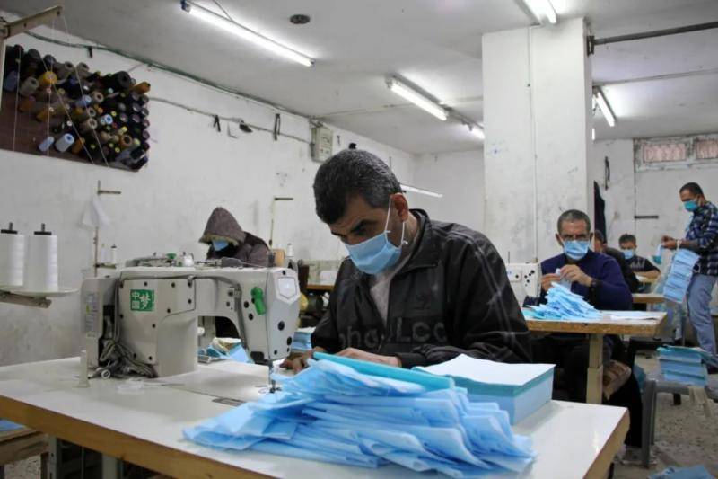  4月13日，在加沙城的一家工厂内，巴勒斯坦工人在生产口罩。新华社发（里泽克摄）