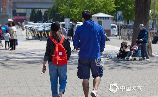 昨天，北京海淀最高气温逼近30℃，行人“秒换”夏装。（图/王晓）