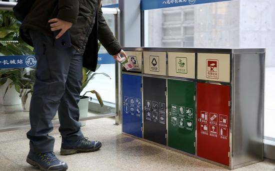 1月15日，京张高铁八达岭长城站，旅客往四类垃圾桶投入垃圾。摄影/新京报记者郑新洽
