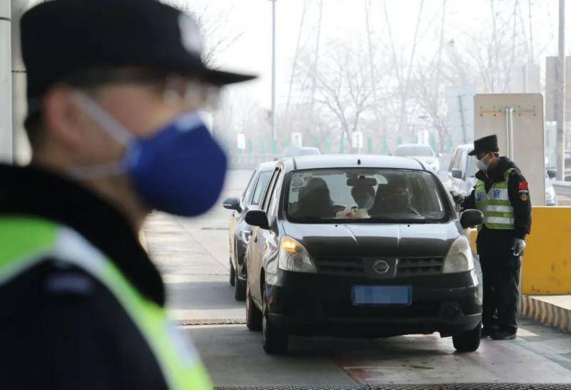 通燕高速白庙进京检查站，民警对进京车辆内的人员核查身份证并测量体温。新京报记者王贵彬摄