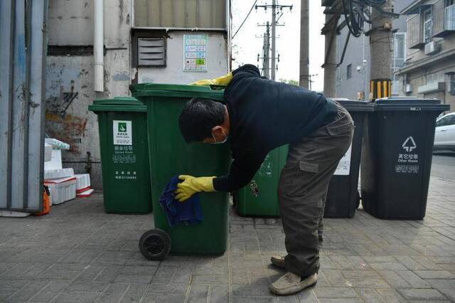 清运员用毛巾将送来的厨余垃圾空桶擦拭干净。摄影/新京报记者吴江