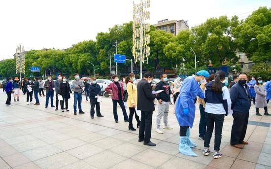 4月14日上午，江夏区纸坊街道郭岭社区居民在市民休闲广场排起长队，等待接受检测。受访者供图