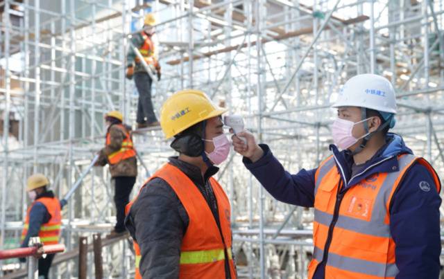 ▲中铁建工集团丰台站项目部一分部生产经理帮工人检测体温。