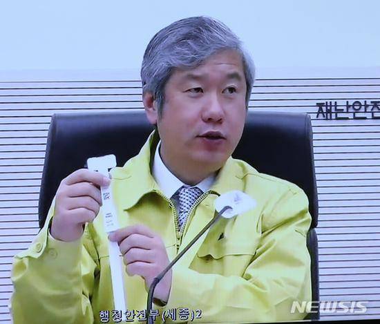 韩国官员展示电子手环实物（纽西斯通讯社）