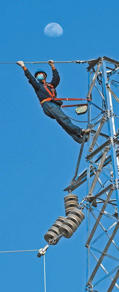 4月4日，在安徽省亳州市谯城区，国网亳州供电公司电力工人正在架设输电线路。张延林摄（影像中国）