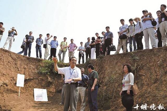 湖北省考古所专家李天元（中）在“郧县人”头骨化石发掘现场介绍发掘情况