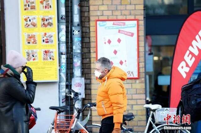 一位购物者佩戴口罩步出柏林市中心的大型超市。中新社记者彭大伟摄