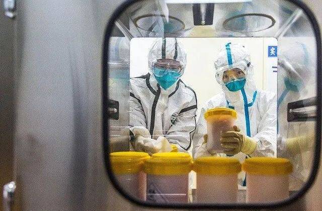 2月 25日，工作人员在中国疾病预防控制中心传染病预防控制所 P3实验室传递窗口接收刚刚从浙江省疾控中心运抵的疫苗生产用新型冠状病毒毒株。