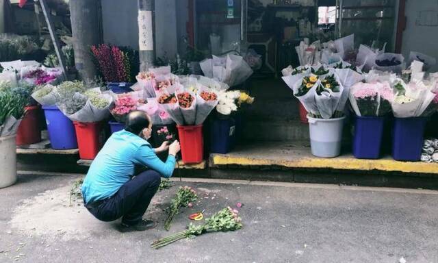 武汉单洞花市，一位店主在检查花束的凋零程度。