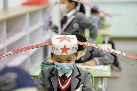 刷屏！杭州小学生头戴“一米帽”上学