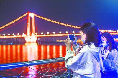 4月25日，武汉两江游览游船正式复航，63名游客登船欣赏大武汉夜景。这是当晚两位医护人员在游船上拍照留影长江日报记者许魏巍摄