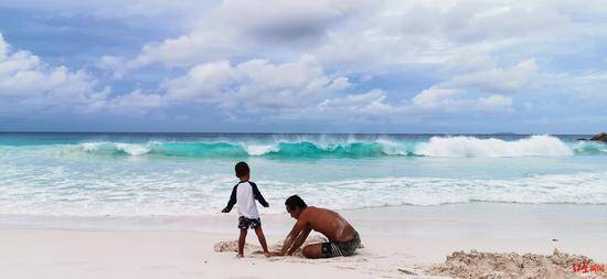 ↑杨洲虎在海滩上陪着3岁的外甥玩耍
