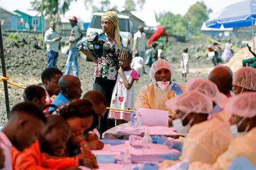  2019年8月5日，在刚果（金）戈马，一名妇女和孩子等候接种埃博拉疫苗。新华社/法新