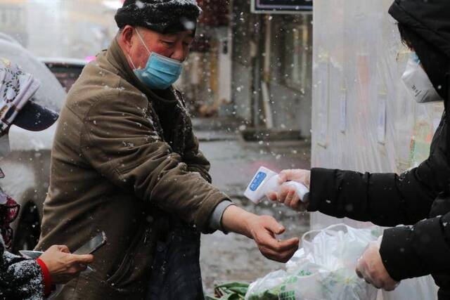 下沉干部雪中为进小区居民测温