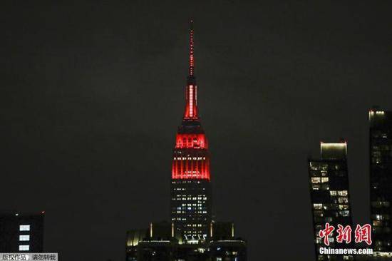 当地时间3月31日，美国纽约帝国大厦点亮红色和白色灯光致敬医疗工作者。