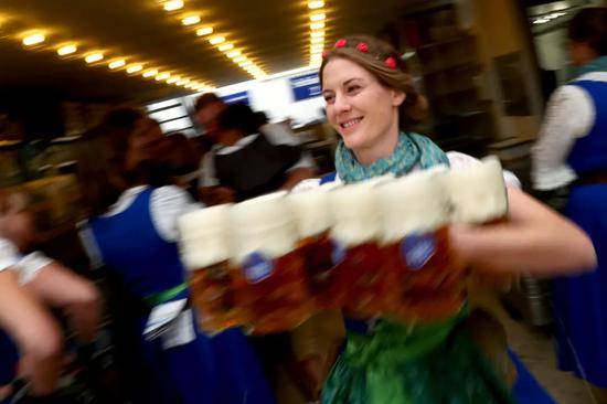 2019年9月21日，在德国慕尼黑，服务员在啤酒节上准备向人们分发啤酒。新华社/美联