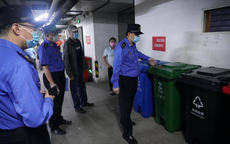 城管队员检查翠微大厦物业的生活垃圾分类收集容器。北京市城管执法局供图