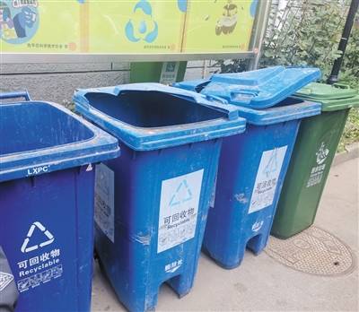 昨日，龙锦苑一区，部分垃圾桶无盖。摄影/新京报记者张璐