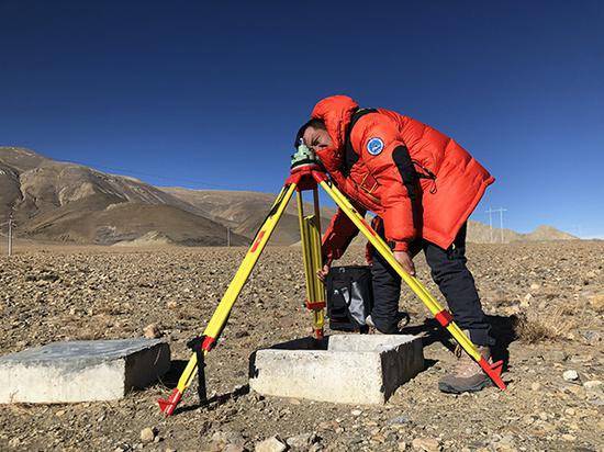 GNSS测量，测量队员正寻找固定标准高度，准备安装链接卫星的设备。