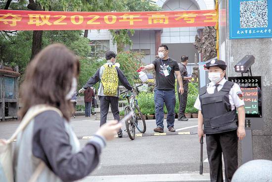 5月6日，武汉市第三十九中学门口，老师在给一名入校的高三学生喷消毒液。当日，武汉教育、公安、卫生、城管、街道等部门已为全市复课学校从学、行、住、吃、医等方面，做好安全准备。（湖北日报全媒记者魏铼通讯员孙逊摄）