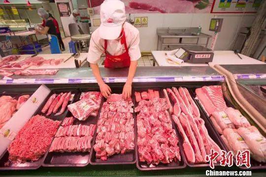 资料图：超市员工在整理猪肉。张云摄