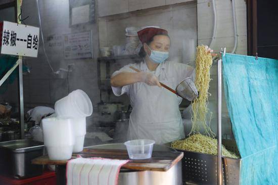 武汉市粮道街的家阳“赵师傅”天天红油热干面店厨师在制作热干面（4月22日摄）。新华社记者沈伯韩摄