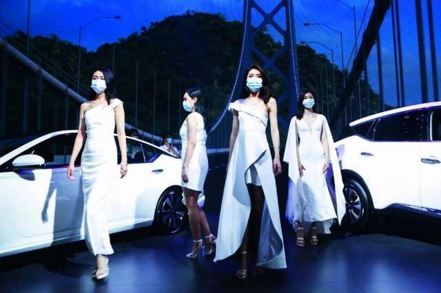  5月2日，在湖南国际会展中心举办的汽车展览会上，一些车模戴着口罩参加活动。图/人民视觉