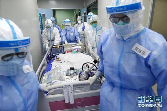 4月24日，武汉协和医院的医护人员将患者转运至手术室。（来源：新华网）