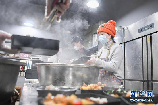 2月26日，爱心人士“雨衣妹妹”（右）在分装盒饭。新华社记者程敏摄