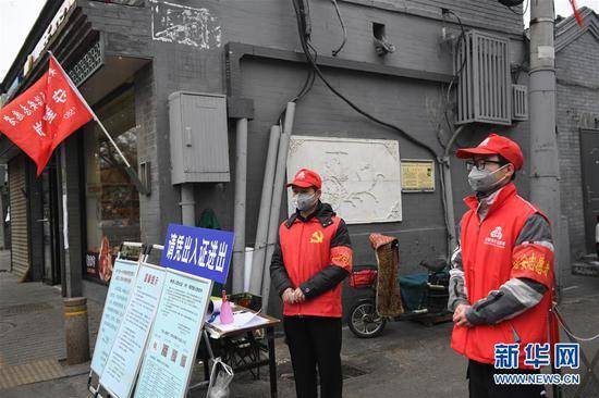 2月27日，志愿者张建国（左）和儿子张洪赫在北京市东城区安定门街道花园社区车辇店胡同口的疫情防控值班点值守。新华社记者鞠焕宗摄