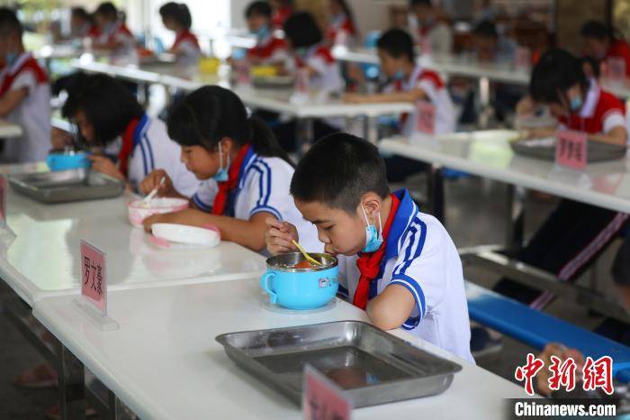 自5月11日起，江西全省中小学生陆续返校学习。为保障学生就餐时的安全，上高县墨山中心小学严格分批次、错时到食堂就餐，就餐时做到错位排列。陈旗海摄