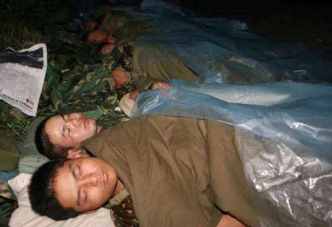 ▲2008年5月15日凌晨，参加抗震救灾的济南军区某部战士在汶川县映秀镇街头休息。