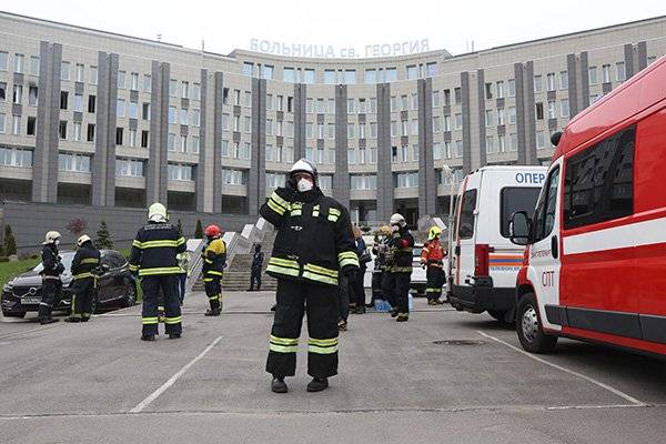 5月12日，在俄罗斯圣彼得堡，消防员站在发生火灾的医院前。新华社图