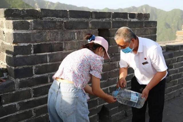 在慕田峪长城上涂字的她，来擦洗长城了……